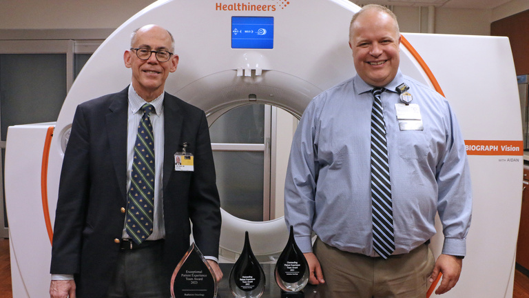 Photo of Drs. Buatti and Allen with the three patient team awards won by the department