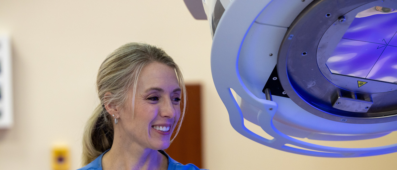 Radiation Technologist next to a Linac