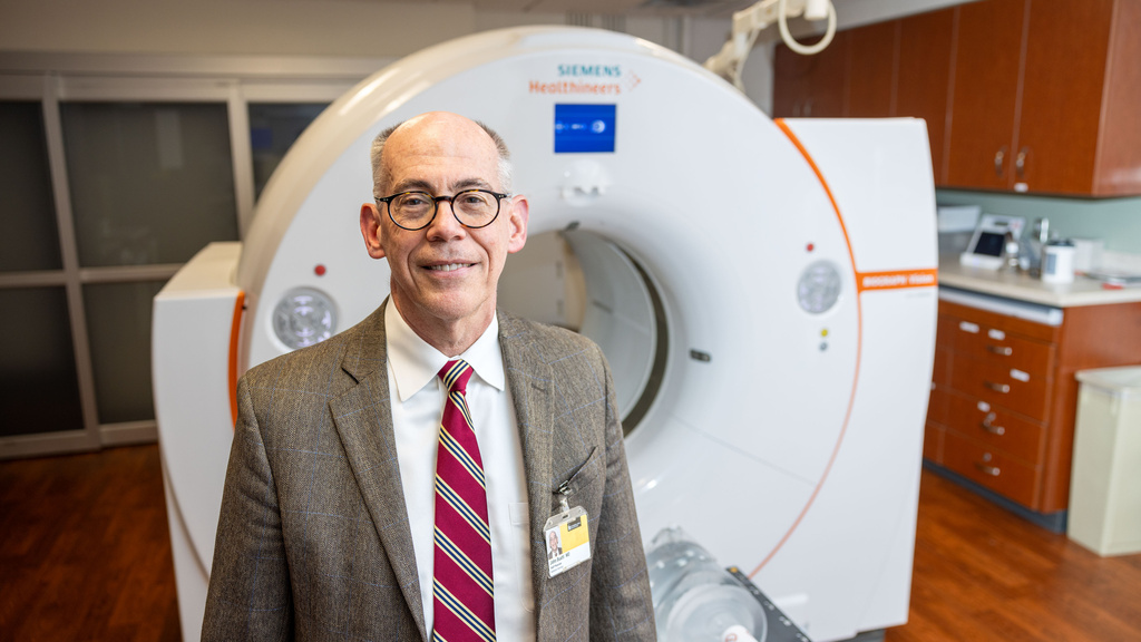 Dr John Buatti, photographed for Medicine Iowa story on theranostics in the Radiation Oncology library and with PET CT machine on Monday, Feb. 5, 2024.